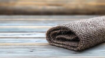Rolled burlap fabric resting on a wooden surface, showcasing a rustic and natural aesthetic photo