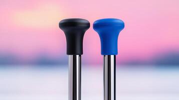 Close-up of two differently colored walking cane handles against a soft pink sunset background photo