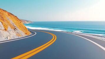 Scenic coastal road winding along the ocean, with cliffs and waves in the background photo