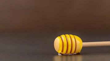 Close-up of a honey dipper with dripping honey on a dark surface, evoking sweetness and warmth photo