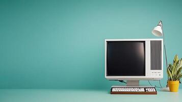 Vintage computer setup on a teal background with a plant and lamp, creating a nostalgic workspace photo
