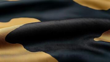 Close-up view of a textured fabric with black and gold patterns, showcasing rich colors and smoothness photo