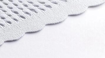 Close-up view of textured white fabric with scalloped edges, highlighting intricate patterns photo