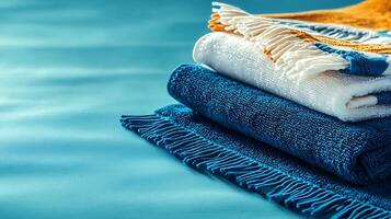 Stacked towels in vibrant colors on a smooth blue surface, creating a relaxing atmosphere photo