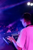 A DJ mixing on stage using board photo