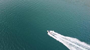 Drone view of a motorboat proceeding at high speed, ploughing through the sea and leaving a wake behind video
