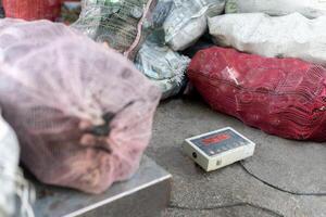 Digital Scale Weighing Recycled Glass Bottles. Close up photo
