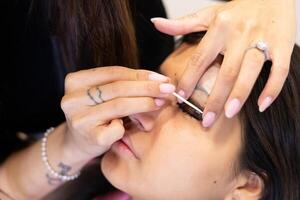 Beautician making eyelash lamination and dyeing procedures. Step by step photo