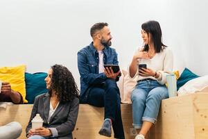 Coworkers in an informal meeting during a break. They discuss company data while having coffee in the break area of the modern coworking office photo