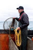 Fisherman working retreating a net from water photo