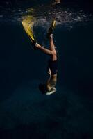 Unrecognizable man in flippers swimming underwater photo