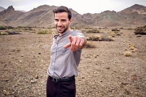 Man pointing with forefinger and looking at camera in highlands photo