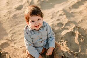 Infant cute boy exploring the sandy river shore in spring. photo