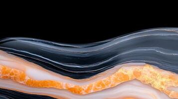 Abstract close-up of layered agate stone with vibrant orange and black patterns on a dark background photo