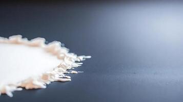 Close-up of a creamy substance spreading on a dark surface, highlighting texture and color photo
