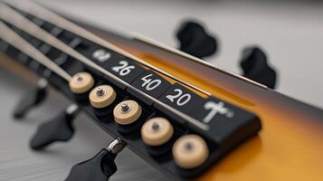 Close-up of a guitar headstock with tuning pegs and fret markers on a blurred background photo