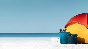 Vibrant beach scene featuring a colorful tent, buckets, and sunglasses against a serene ocean backdrop photo