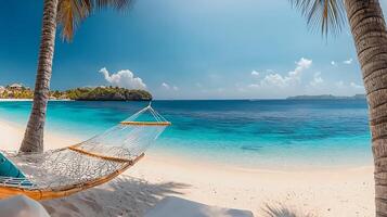 Serene beach scene with a hammock swaying between palm trees under a clear blue sky photo