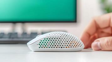 Sleek white gaming mouse on a desk with a blurred computer monitor in the background photo