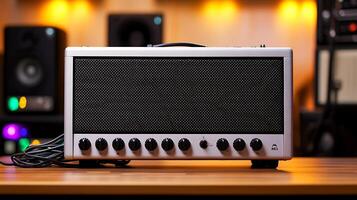 Modern audio amplifier on a wooden table with blurred studio equipment in the background photo