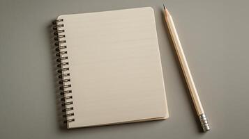 Blank spiral notebook with a pencil on a minimalist gray background, ideal for note-taking or sketching photo