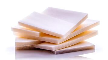 Stack of translucent white plastic sheets arranged artistically on a reflective surface photo