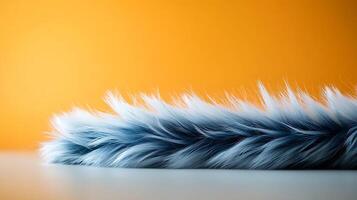 Soft blue fur lying on a smooth surface against a vibrant orange background, creating contrast photo