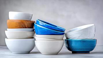 Stacked bowls of various colors and materials arranged artistically on a neutral background photo