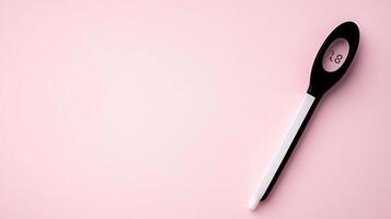 Digital thermometer resting on a soft pink surface, indicating temperature for health monitoring photo