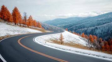 Serene winding road through autumn trees and snow-capped mountains under a cloudy sky photo