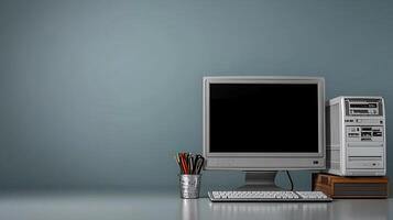 Vintage computer setup with monitor and tower on a desk against a minimalist gray wall photo