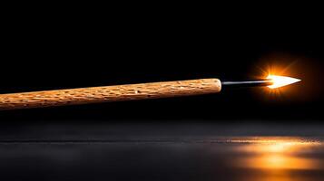 Close-up of a wooden spear with a glowing tip on a dark background, highlighting craftsmanship photo