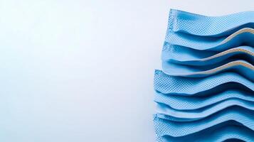 Close-up of folded blue textured fabric showcasing intricate patterns against a light background photo