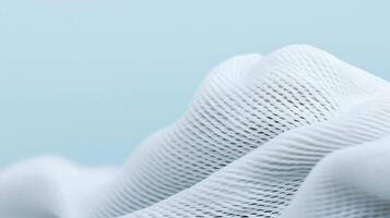 Close-up view of soft white fabric texture with gentle waves against a light blue background photo