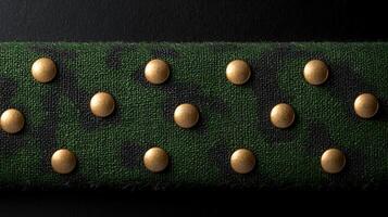 Close-up view of a textured green fabric with gold studs, showcasing a military-inspired design photo
