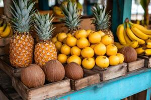 Colorful tropical fruits arranged on wooden crates at a market, offering a refreshing and exotic display photo