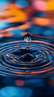 Water drop creating concentric ripples on colorful surface photo