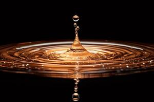 Golden water drop splashing and creating concentric ripples on dark background photo