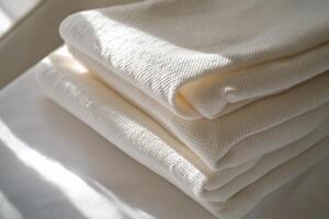 Soft white linen fabric neatly stacked indoors photo