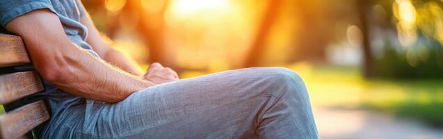 A man sitting on a bench with his hands on his knees photo