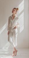 A woman in white pants and shirt standing in a room photo