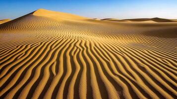 Rippling sand dunes under a clear blue sky photo
