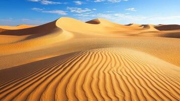 Waves of sand under a bright blue sky in the desert photo