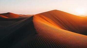 The sun is setting over a desert dune photo
