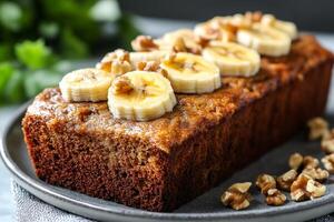 Delicious homemade banana bread loaf decorated with banana slices and walnuts photo