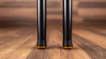 Close-up view of two sleek, modern tripod legs on a wooden floor, showcasing design and texture photo