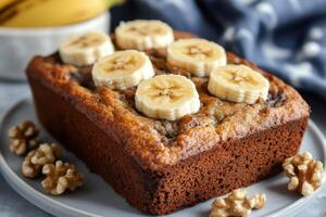 Delicious homemade banana bread loaf decorated with fresh banana slices and walnuts photo