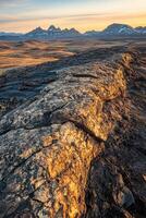 The sun sets over the mountains in iceland photo