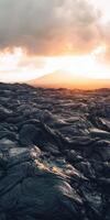 A lava field with the sun setting over it photo