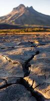 Cracked earth in the middle of a desert with mountains in the background photo